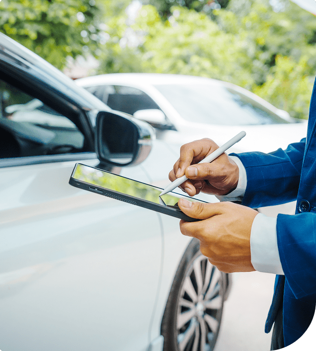 Rectangle 28 Person signing on tablet near parked car.